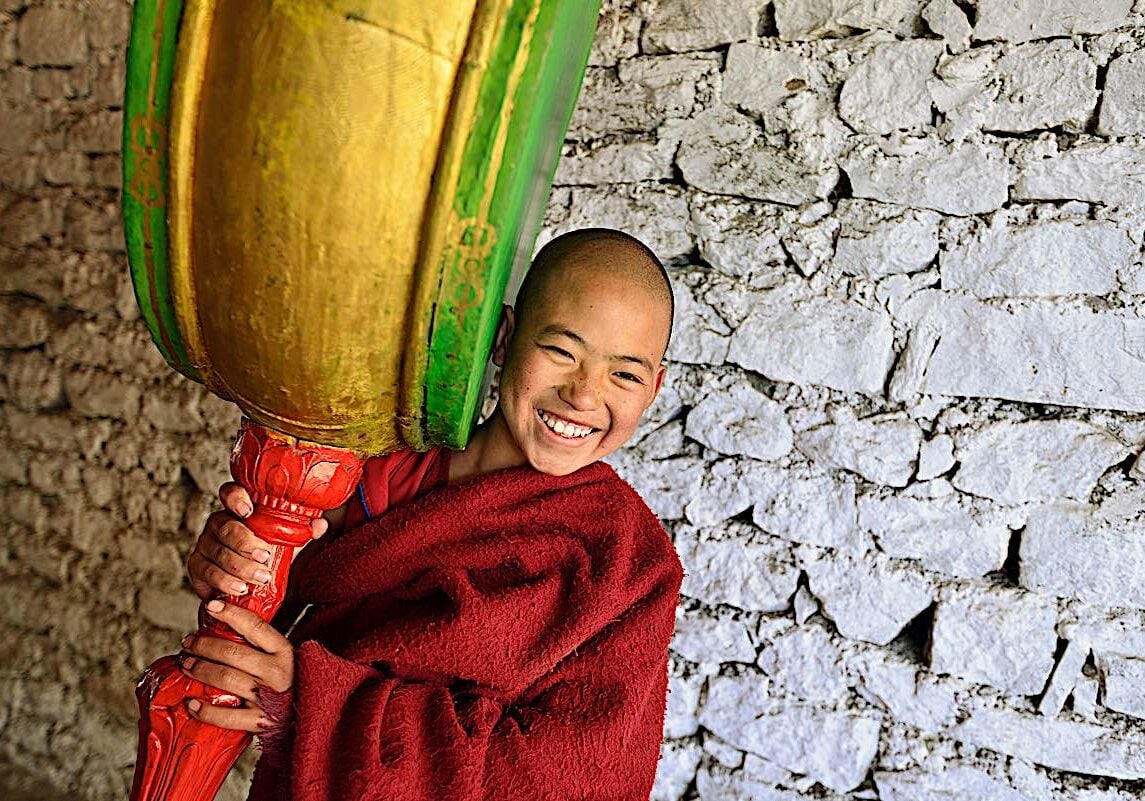 A young monk plays a drum at Tawang Togya festival at a temple in Arunachel Pradesh India.