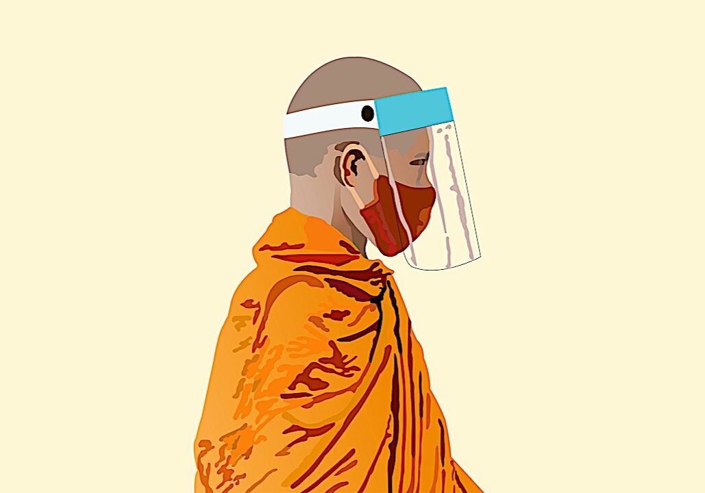 A Buddhist monk with mask and face protection continues to teach, overcoming all obstacles.