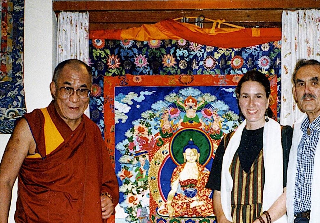 His Holiness the Dalai Lama with author/artist Leslie Rinchen-Wongmo and her father, standing in front of one of Leslie's magnificent silk appliqué thangkas — in 1997 in Dharamsala.