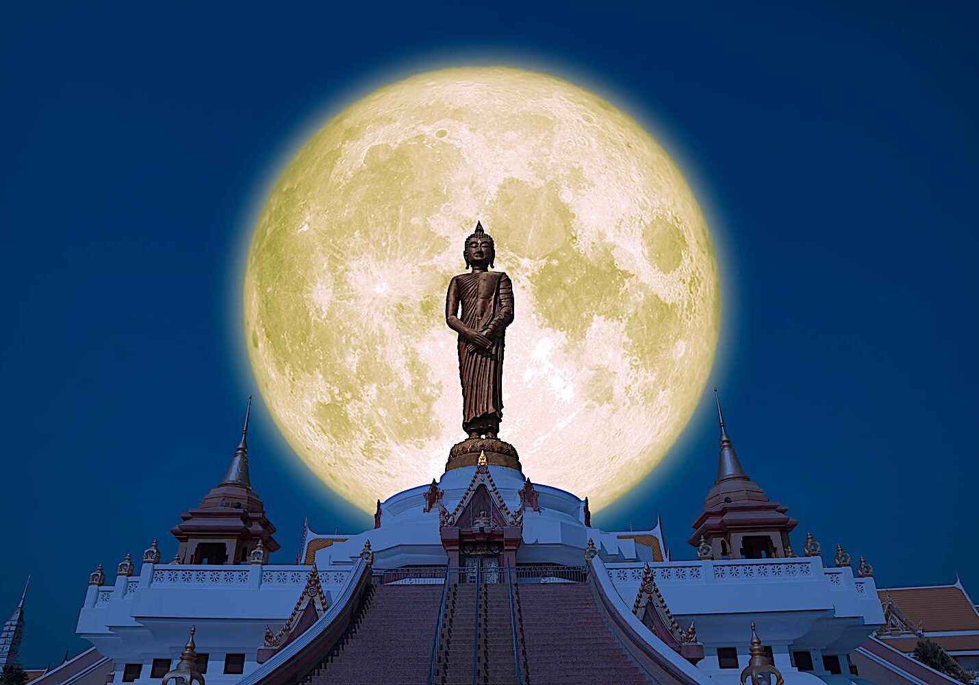 Buddha statue against a full moon.