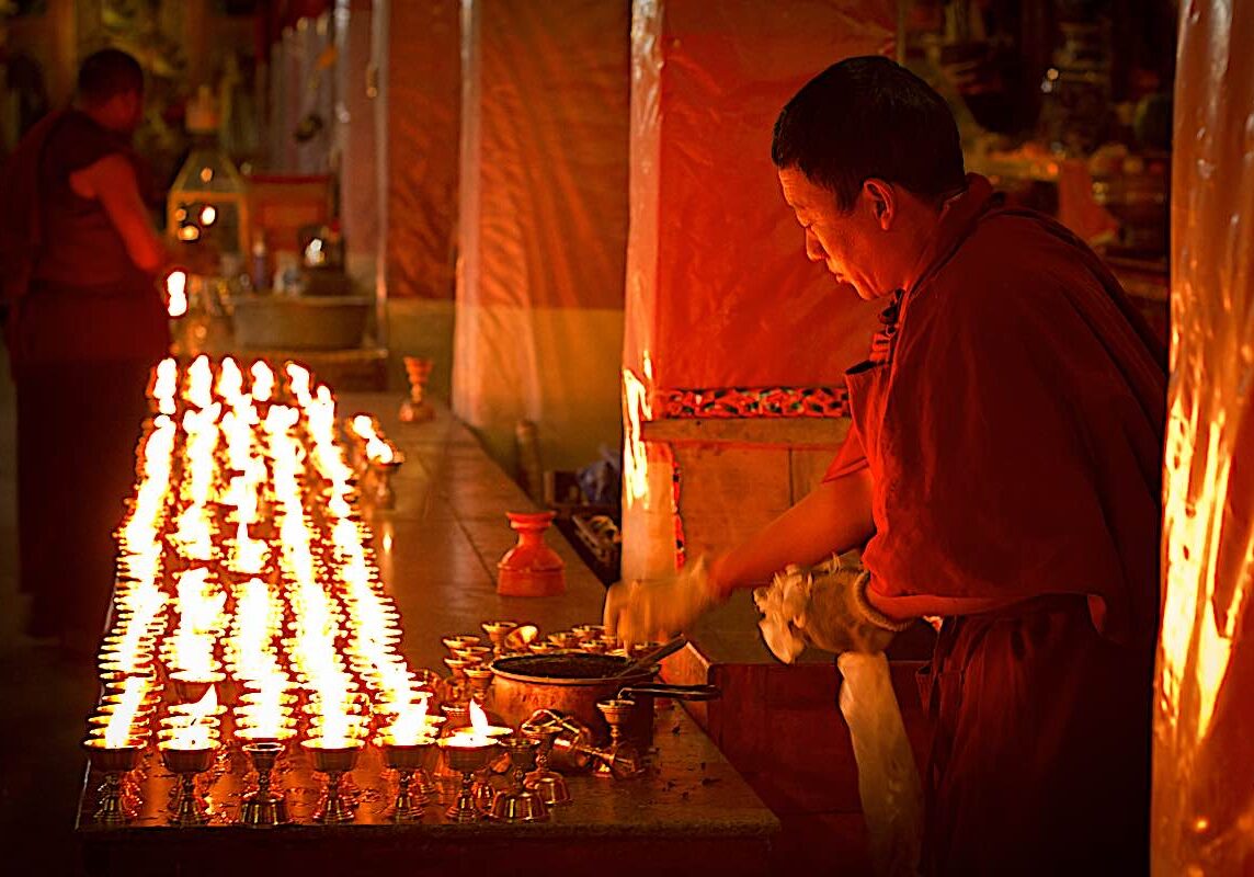 Monk making offering on Holy Day in Drepung Monastery Lhasa Tibet.