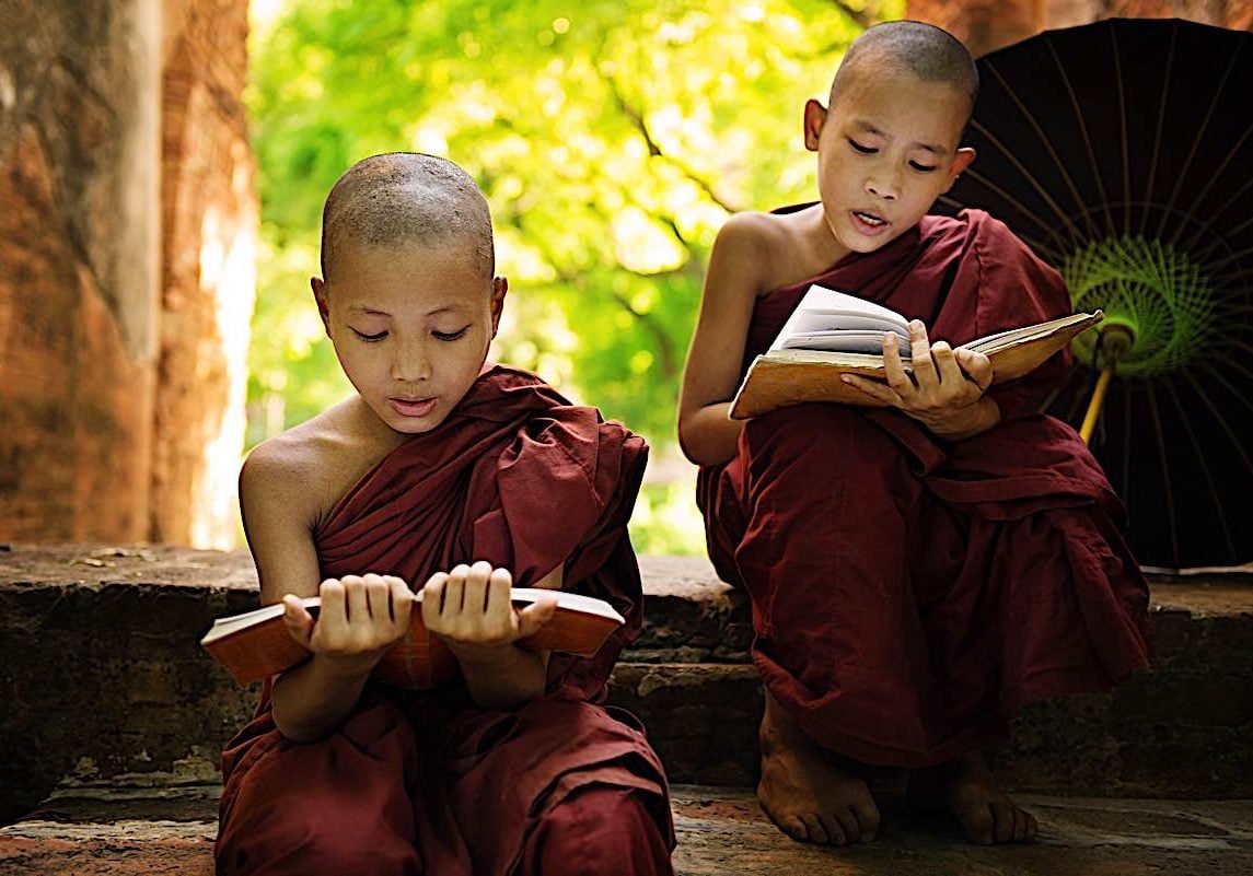 Two young monks recite sutras out loud, a meritorious practice.