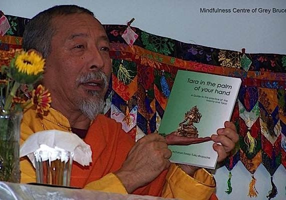 Venerable Zasep Rinpoche teaching at a Tara weekend using the commentary book, Tara in the Palm of Your Hand, as a reference.